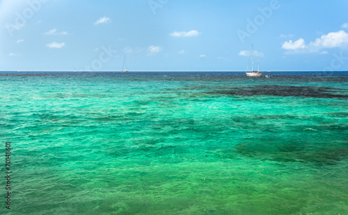Sailing boat on turquoise mediterranean water in Ibiza island
