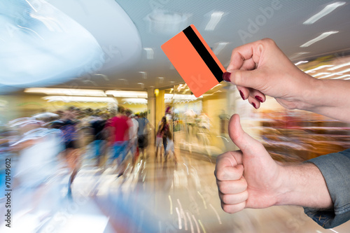 Woman holding credit card, man gesturing thumb up