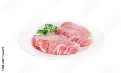 Raw pork steaks on plate.