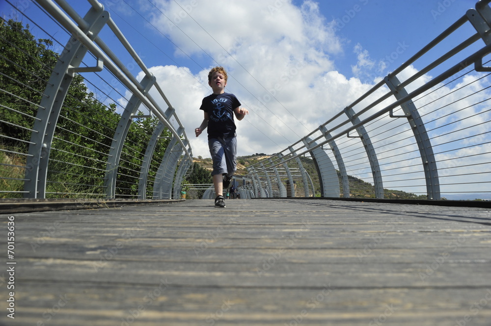 Boy running on the mountain bridge