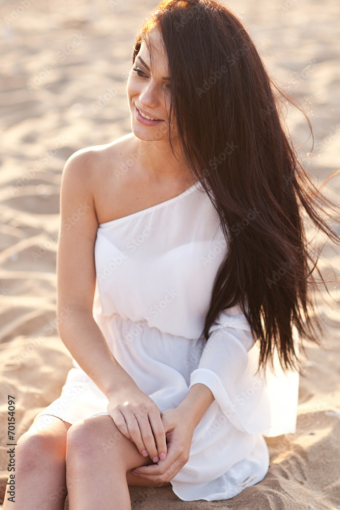 Beautiful tender woman posing on the sunset beach Beautiful tender woman posing on the sunset beach
