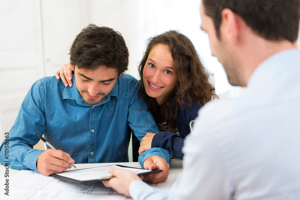 Young attractive couple signing contract Young attractive couple signing contract