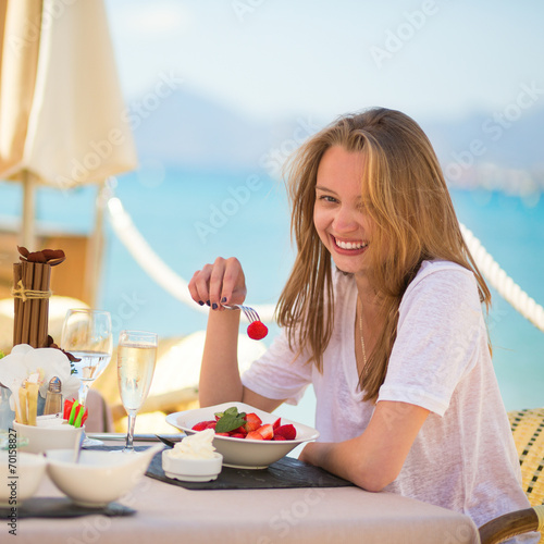 Young woman eating fruits in a beach restaurant © Ekaterina Pokrovsky
