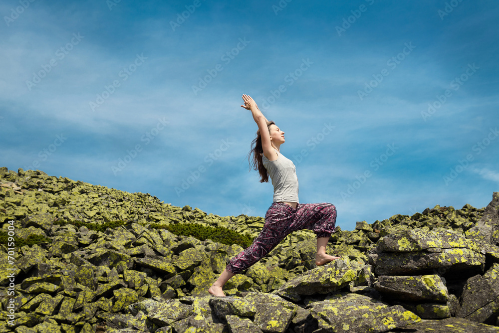 Woman doing yoga exercise on fresh air with blue sky on backgrou Woman doing yoga exercise on fresh air with blue sky on backgrou