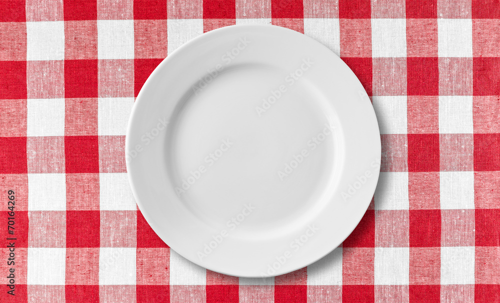 Empty white plate on checkered red tablecloth Empty white plate on checkered red tablecloth