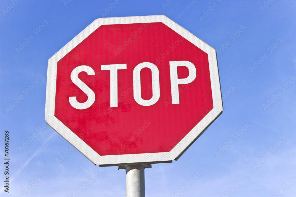 Stop road traffic sign over blue sky