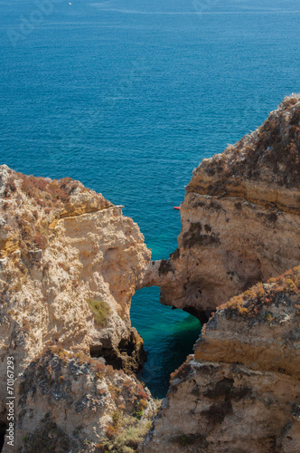 Algarve coast, Portugal. Rocks in the shoreline and blue water