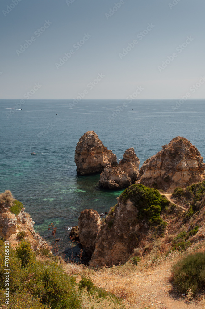 Algarve coast, Portugal. Rocks in the shoreline and blue water