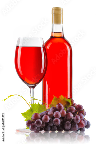 Glass of rose wine with bottle and ripe grapes isolated