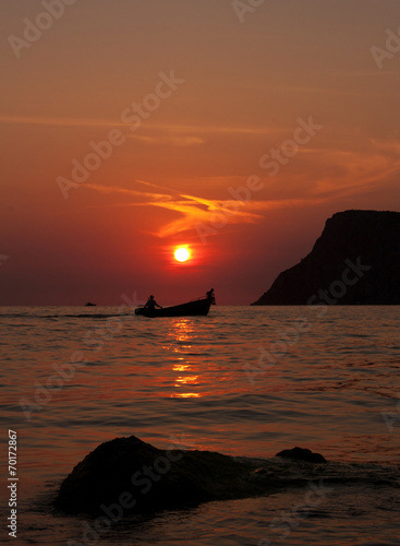 Two people in a boat at sunset