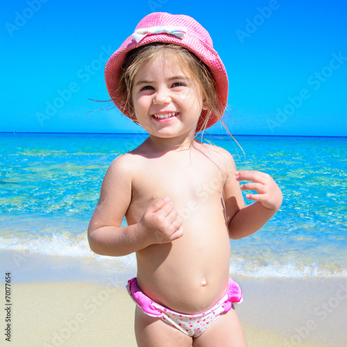 Bambina al mare con cappello rosa