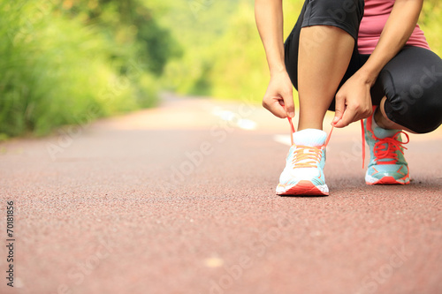 woman runner tying shoelace 