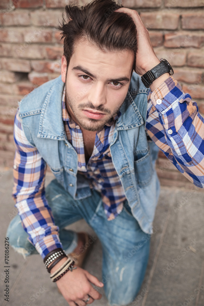 man sitting with one hand in his hair man sitting with one hand in his hair