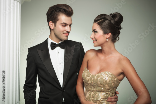 man in tuxedo embracing his woman and smiles