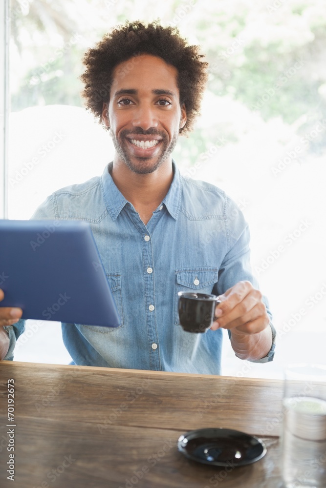 Casual man having coffee while using tablet Casual man having coffee while using tablet