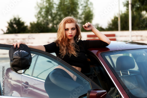 Young pretty lady with a clasic car