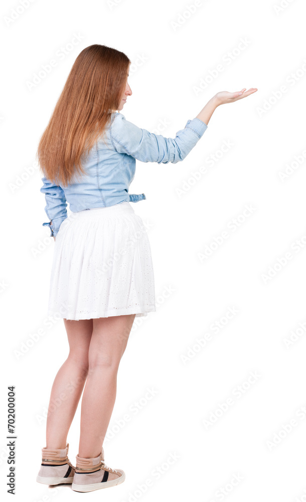 Back view of Beautiful woman in dress looking at wall and Holds Back view of Beautiful woman in dress looking at wall and Holds