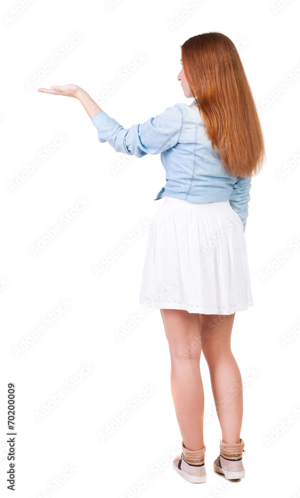 Back view of Beautiful woman in dress looking at wall and Holds Back view of Beautiful woman in dress looking at wall and Holds