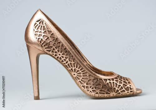Woman gold shoes on background