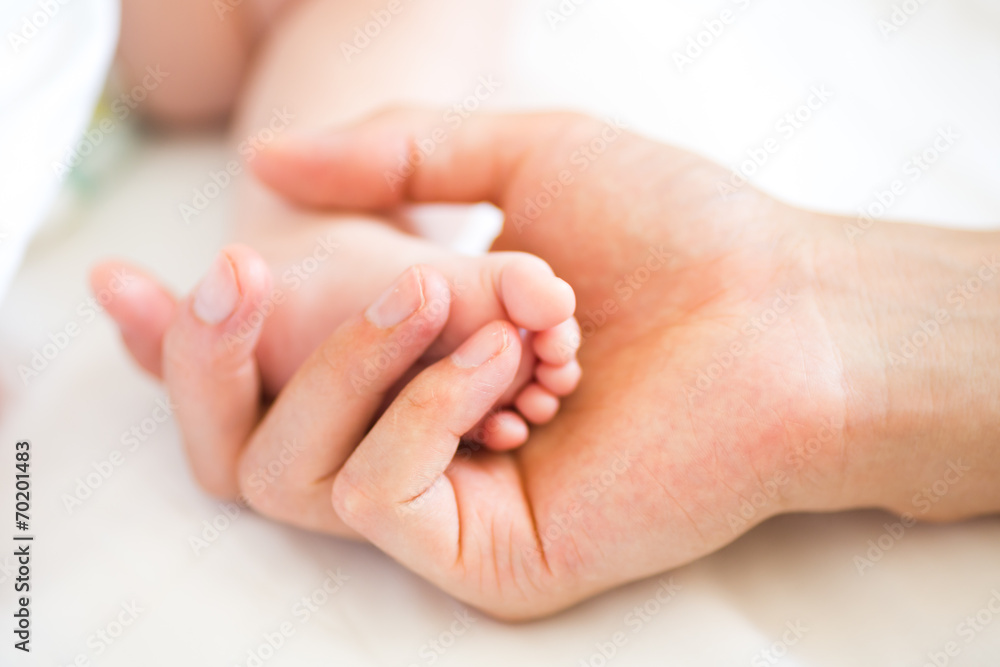 Father holding the foot of his new born son Father holding the foot of his new born son
