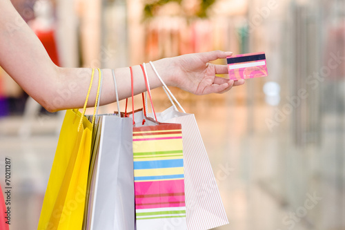 Female hand holding shopping bags and credit card