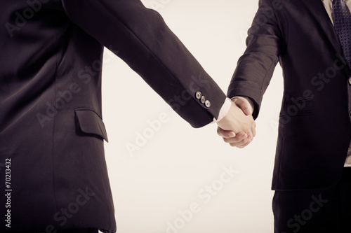 Two business people shaking hands. Isolated on white background. © Nonwarit