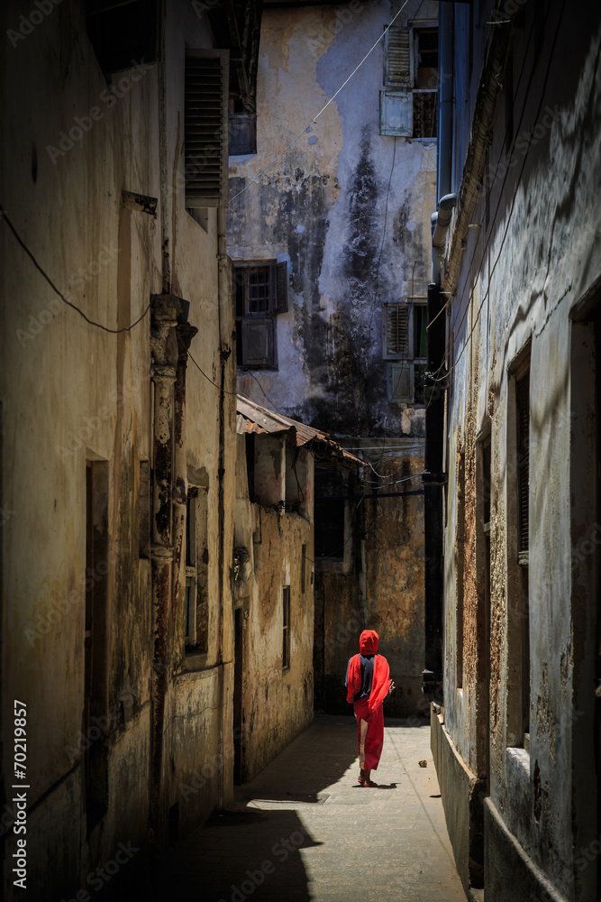 Veiled woman walking through a narrow street