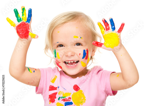 Portrait of a cute little girl playing with paints