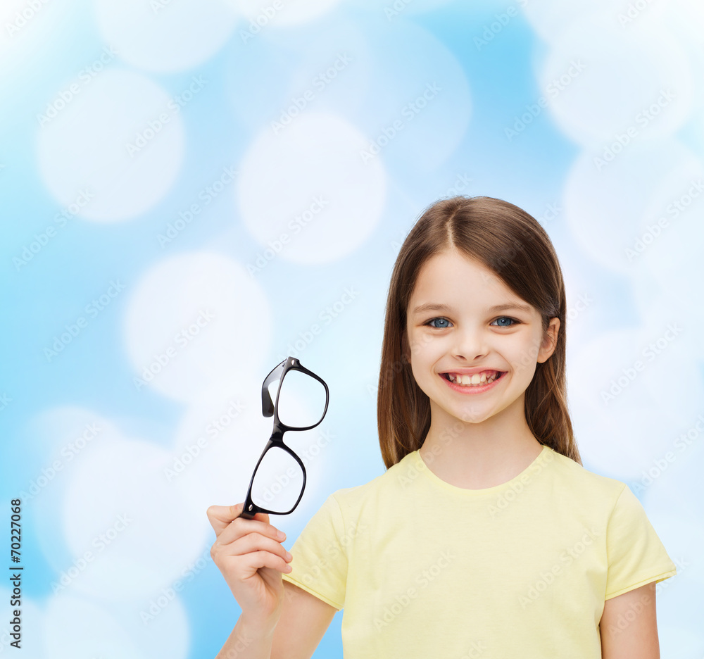 smiling cute little girl holding black eyeglasses smiling cute little girl holding black eyeglasses