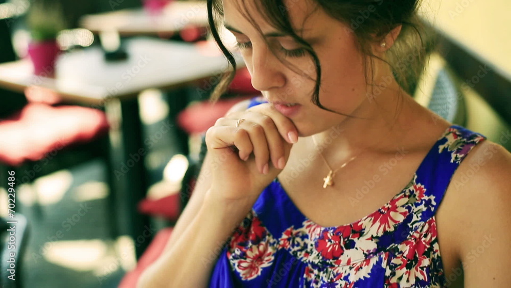 Pretty woman in beautiful dress reading menu in the street cafe