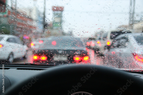 Driving on a rainy in a city, view from inside.
