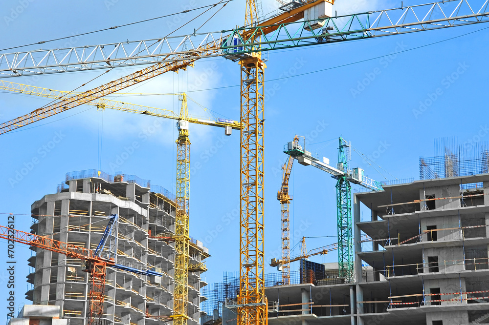 Crane and building construction site against blue sky Crane and building construction site against blue sky