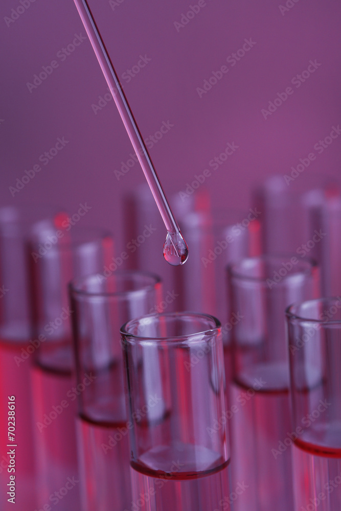 Test-tubes with blue liquid and stick on purple background Test-tubes with blue liquid and stick on purple background