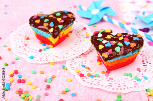 Delicious rainbow cakes on paper napkin  on bright background