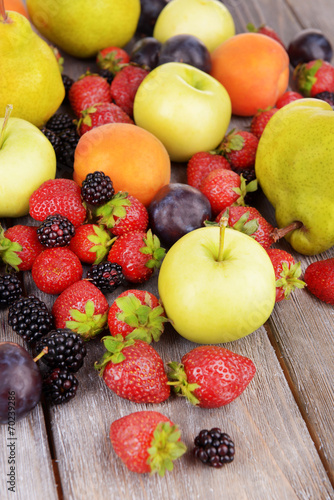 Ripe fruits and berries on wooden background