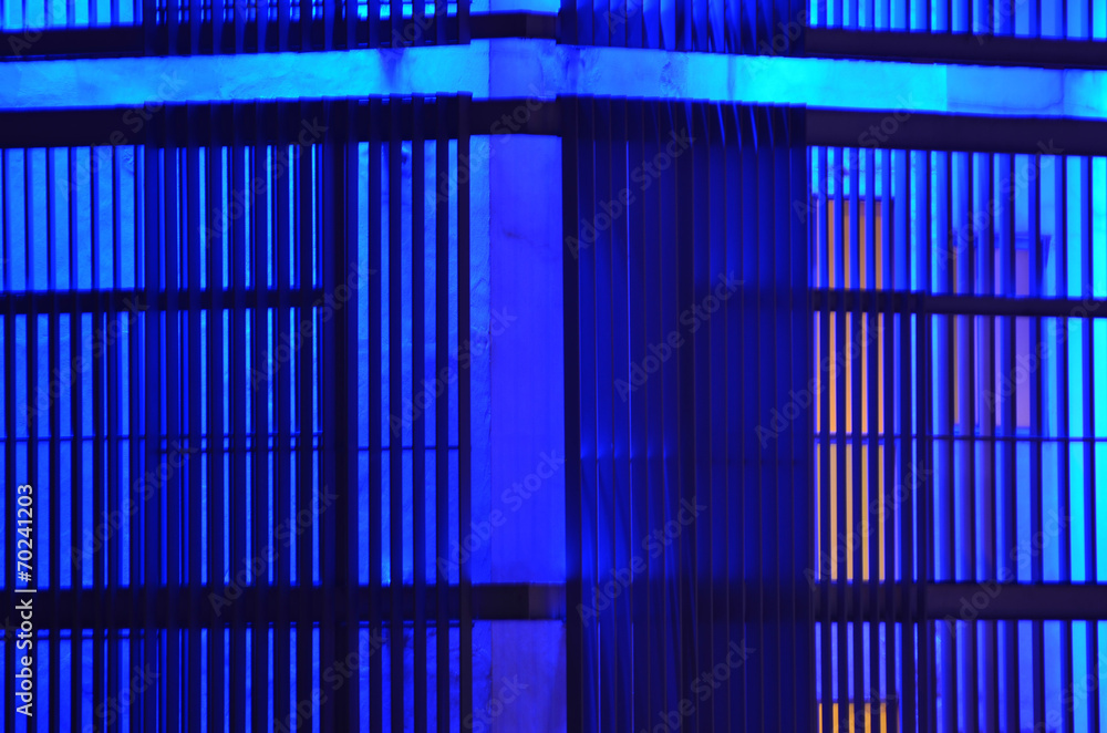 Closeup of office building wall design - all in blue fluorescent light