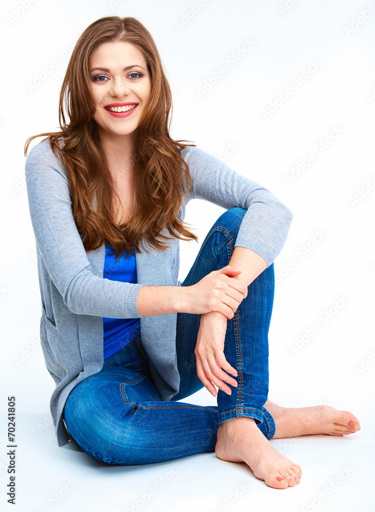 Casual style young woman posing on white floor.