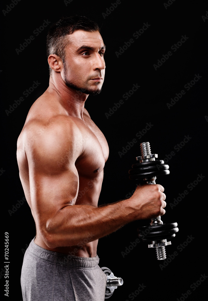 Portrait of a sportsman lifting dumbbells over black background Portrait of a sportsman lifting dumbbells over black background
