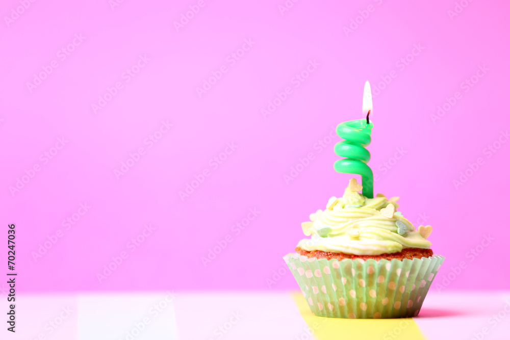 Delicious birthday cupcake on table on pink background Delicious birthday cupcake on table on pink background