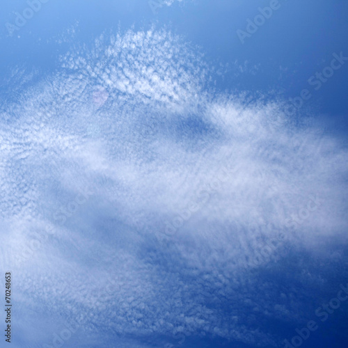 layer of broken stratus clouds under deep blue sky © elenarostunova