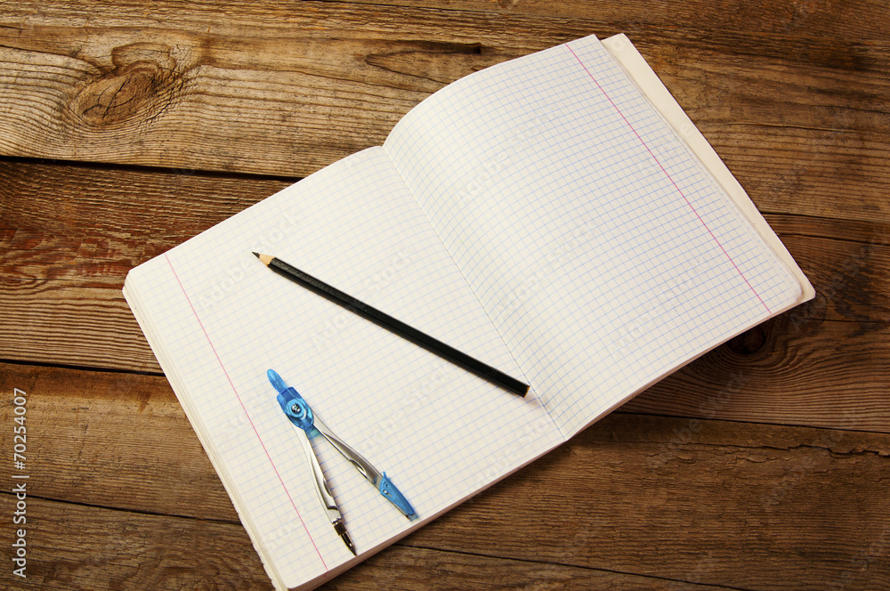 Blank paper, pencil and compasses, on the wooden table. Blank paper, pencil and compasses, on the wooden table.