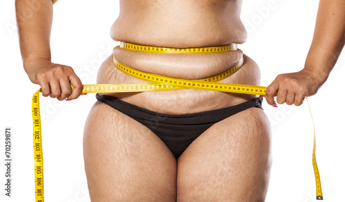 very fat woman measure her waist with tape photo