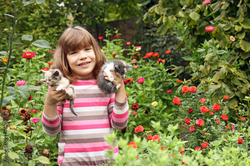 happy little girl holding kittens