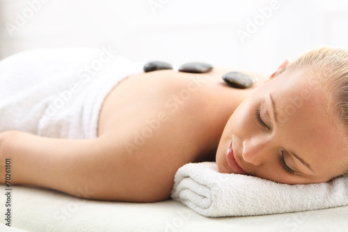 Masaż gorącymi kamieniami, kobieta w salonie spa