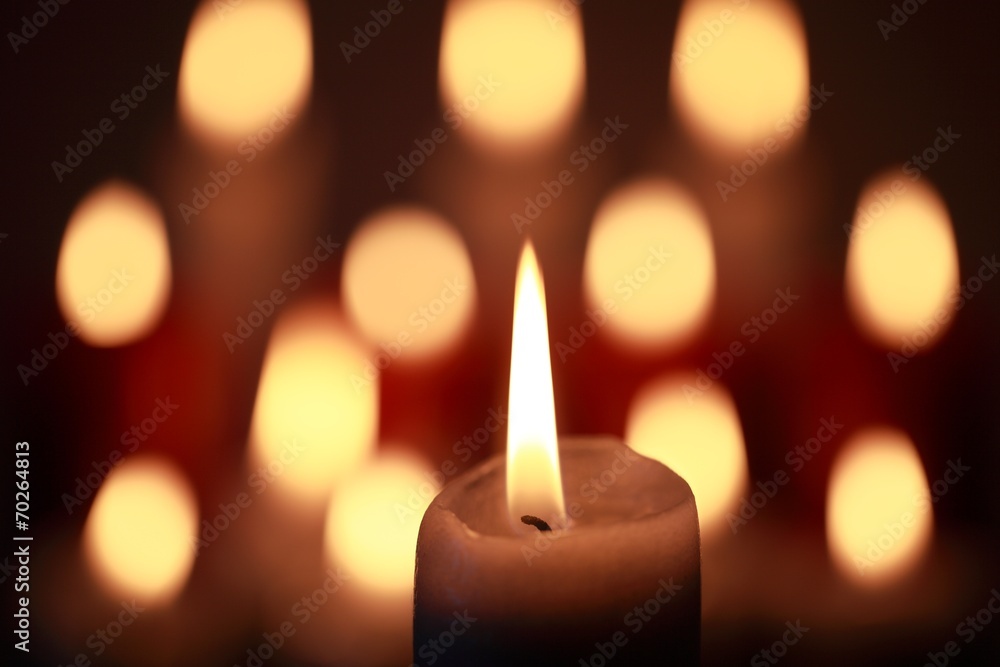Kerze mit Lichtreflexen im Hintergrund