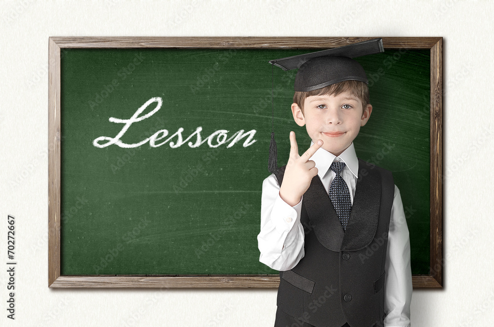 Cheerful little boy on blackboard. Looking at camera Cheerful little boy on blackboard. Looking at camera