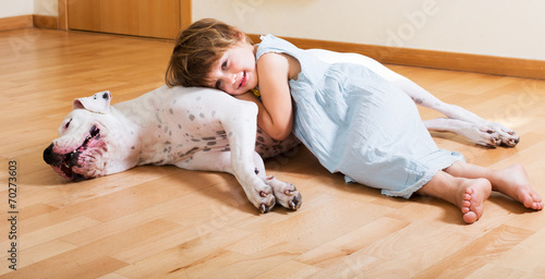Little girl hugging white dog
