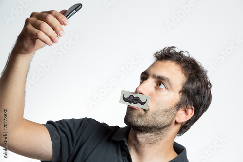 casual man make selfie portrait with fake moustache