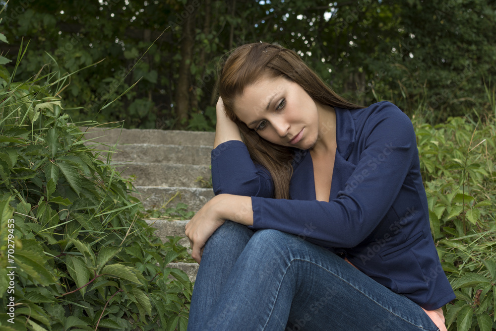 Sad thoughtful woman sitting on stairs Sad thoughtful woman sitting on stairs