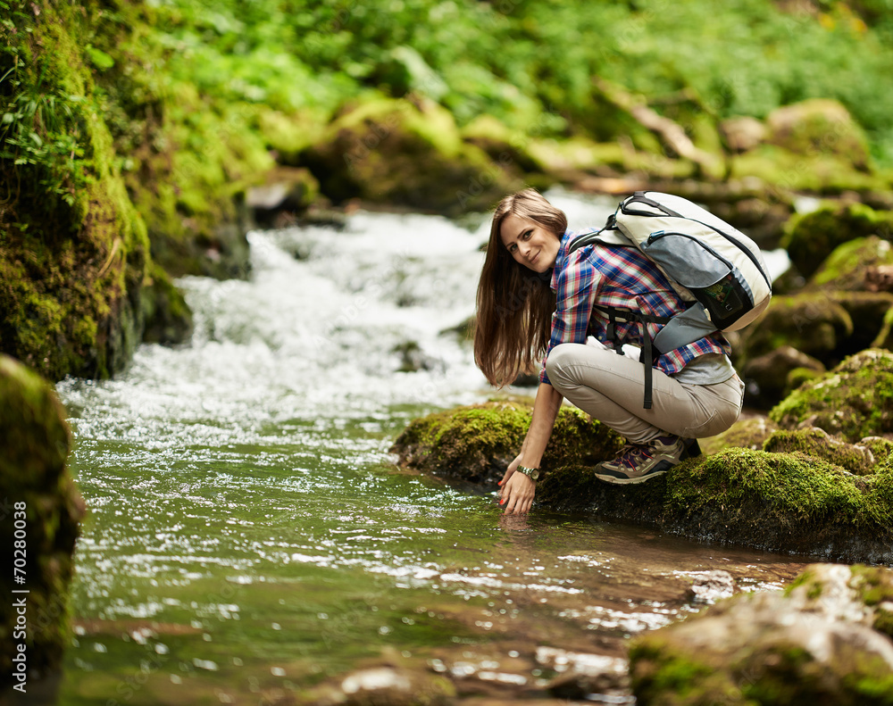 Fototapeta premium Young woman hiker by the river